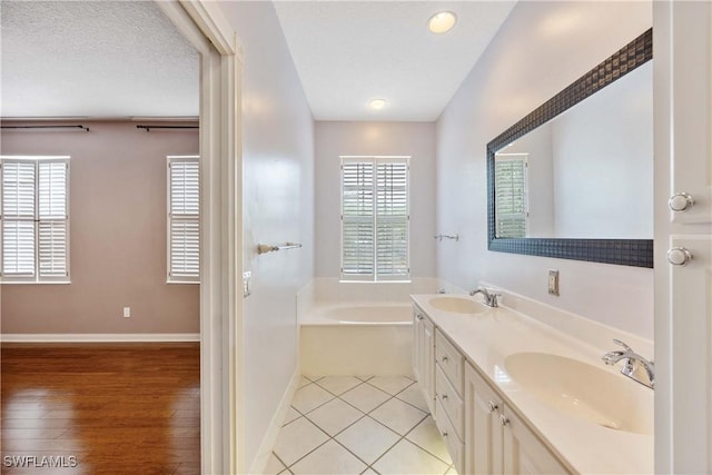 5831 Cove Cir Unit 6, Naples, FL 34119 - full bathroom featuring a bath, double vanity, baseboards, and tile patterned floors