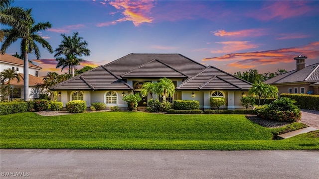 8241 Glenfinnan Cir, Fort Myers, FL 33912 - ranch-style house featuring a lawn, stucco siding, and a tiled roof