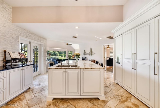 8241 Glenfinnan Cir, Fort Myers, FL 33912 - kitchen with a sink, stone tile flooring, ceiling fan, open floor plan, and light stone countertops