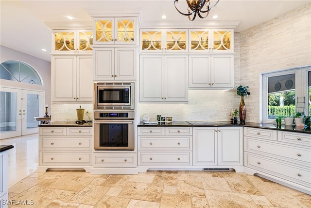 8241 Glenfinnan Cir, Fort Myers, FL 33912 - kitchen with appliances with stainless steel finishes, dark countertops, french doors, decorative backsplash, and recessed lighting