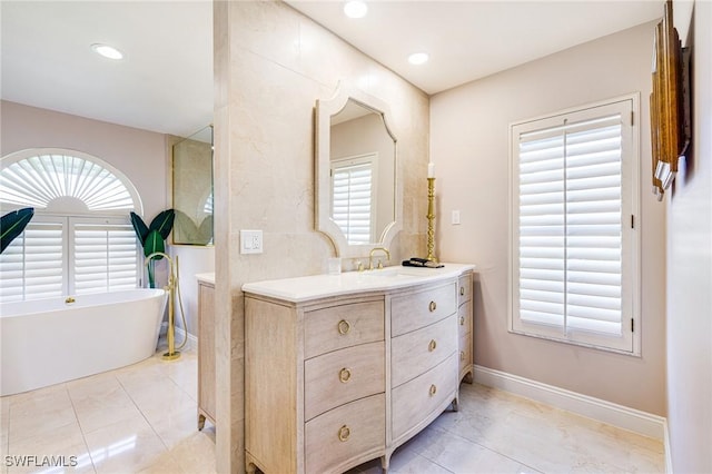 8241 Glenfinnan Cir, Fort Myers, FL 33912 - full bath featuring a freestanding tub, vanity, baseboards, recessed lighting, and tile patterned flooring