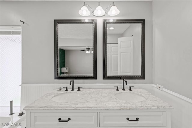 1311 SE 11th St, Cape Coral, FL 33990 - full bathroom with double vanity, ceiling fan, and wainscoting