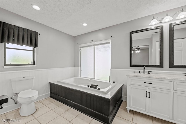 1311 SE 11th St, Cape Coral, FL 33990 - full bath with wainscoting, a textured ceiling, vanity, a bath, and toilet