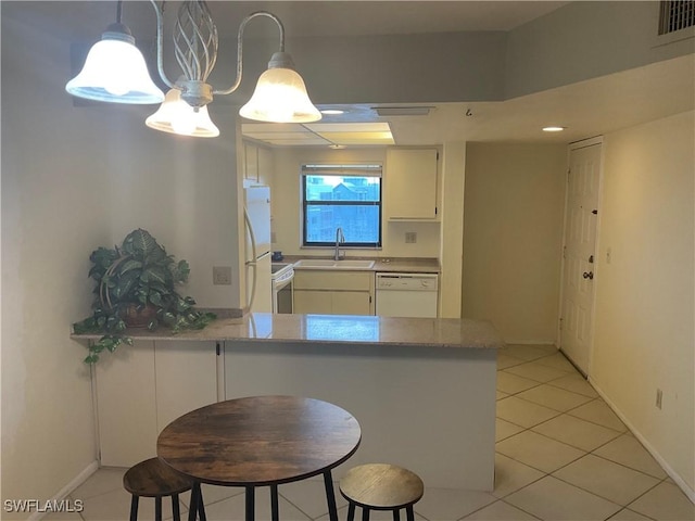 6897 Estero Blvd Unit 166, Fort Myers Beach, FL 33931 - kitchen featuring white appliances, a peninsula, light tile patterned floors, white cabinets, and decorative light fixtures