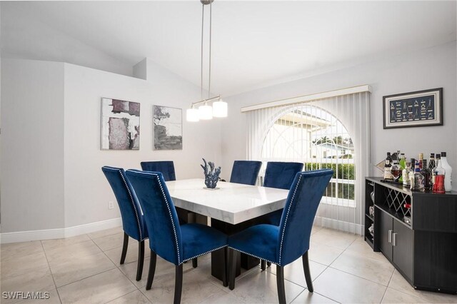 227 SW 48th Ter, Cape Coral, FL 33914 - dining area with vaulted ceiling, light tile patterned floors, and baseboards