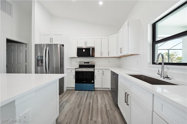 4309 NW 38th Ave, Cape Coral, FL 33993 - kitchen featuring stainless steel appliances, a sink, white cabinets, light countertops, and high vaulted ceiling