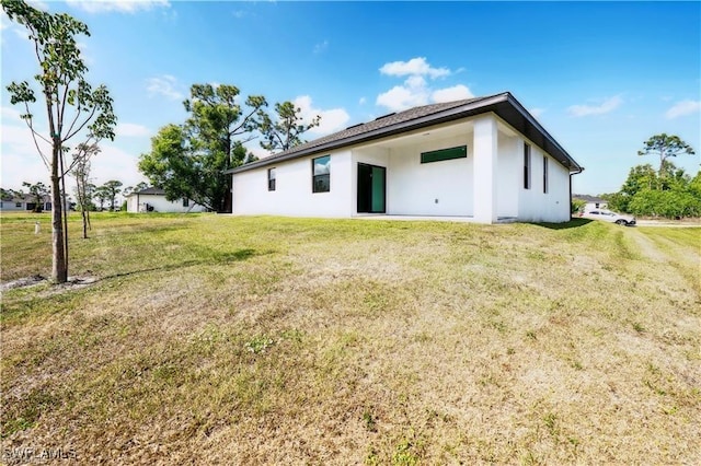 4309 NW 38th Ave, Cape Coral, FL 33993 - rear view of house with stucco siding and a yard
