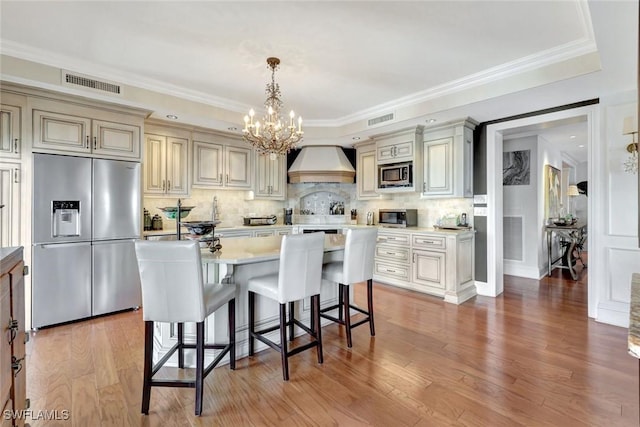 1920 Virginia Ave Unit 1602, Fort Myers, FL 33901 - kitchen featuring appliances with stainless steel finishes, premium range hood, cream cabinetry, a chandelier, and light countertops