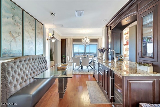 1920 Virginia Ave Unit 1602, Fort Myers, FL 33901 - kitchen with a chandelier, wood finished floors, decorative light fixtures, light stone countertops, and ornamental molding