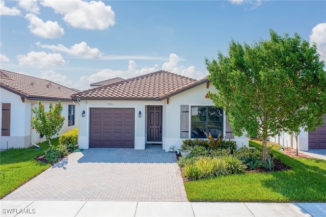 5536 Morino Way, Ave Maria, FL 34142 - mediterranean / spanish home with an attached garage, decorative driveway, a tile roof, stucco siding, and a front yard