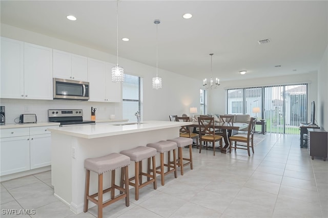 5536 Morino Way, Ave Maria, FL 34142 - kitchen featuring appliances with stainless steel finishes, a sink, plenty of natural light, a center island with sink, and recessed lighting