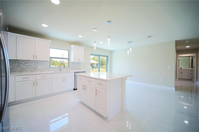 1895 Weldon Ave, Lehigh Acres, FL 33972 - kitchen featuring a sink, backsplash, light countertops, white cabinetry, and recessed lighting
