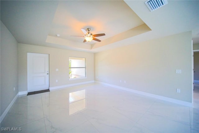 1895 Weldon Ave, Lehigh Acres, FL 33972 - spare room with a raised ceiling, a ceiling fan, baseboards, and light marble finish floors