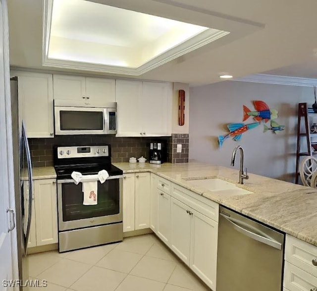 17170 Harbour Point Dr Unit 736, Fort Myers, FL 33908 - kitchen featuring appliances with stainless steel finishes, a sink, a tray ceiling, light tile patterned flooring, and backsplash