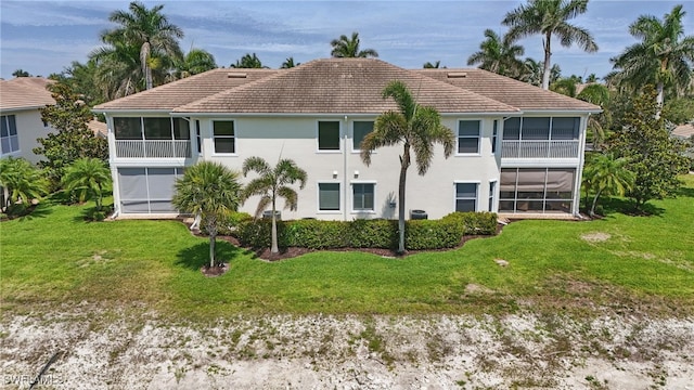 28657 San Lucas Ln Unit 102, Bonita Springs, FL 34135 - rear view of property featuring a sunroom, a tiled roof, a yard, and stucco siding