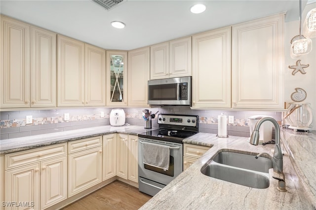 2608 NW 25th Ave, Cape Coral, FL 33993 - kitchen featuring appliances with stainless steel finishes, cream cabinetry, a sink, decorative backsplash, and recessed lighting
