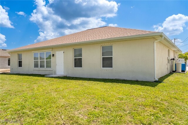 2608 NW 25th Ave, Cape Coral, FL 33993 - rear view of property featuring a lawn and stucco siding