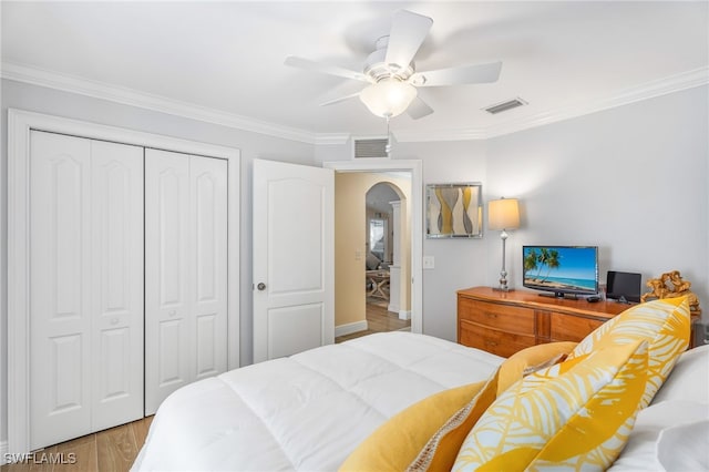 2608 NW 25th Ave, Cape Coral, FL 33993 - bedroom featuring arched walkways, a closet, ornamental molding, wood finished floors, and a ceiling fan