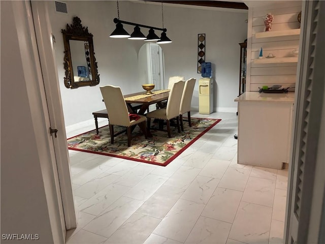 5504 Brookfield St, Lehigh Acres, FL 33971 - dining room with light marble finish floors, arched walkways, and baseboards