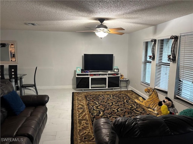 5504 Brookfield St, Lehigh Acres, FL 33971 - living room with ceiling fan, a textured ceiling, and baseboards