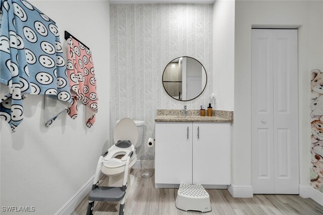 1158 E Benbow Cir, Labelle, FL 33935 - bathroom with a closet, wallpapered walls, vanity, toilet, and wood finished floors