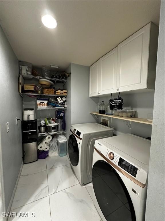 1839 Jovita Ave, Lehigh Acres, FL 33972 - laundry area with independent washer and dryer, light marble finish floors, and cabinet space