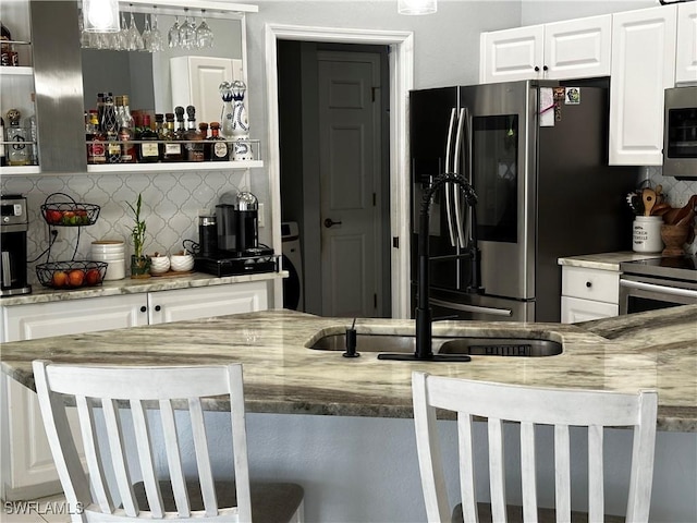 1839 Jovita Ave, Lehigh Acres, FL 33972 - kitchen featuring stainless steel appliances, backsplash, white cabinetry, and light stone countertops