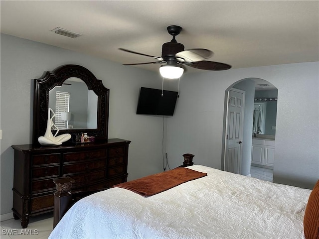 1839 Jovita Ave, Lehigh Acres, FL 33972 - tiled bedroom with arched walkways, a ceiling fan, and connected bathroom