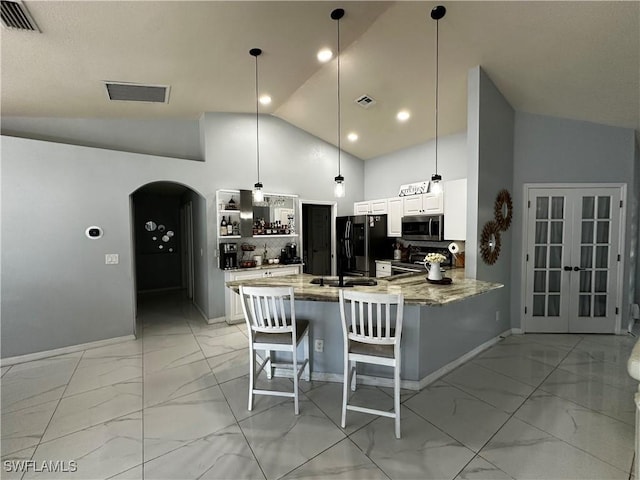 1839 Jovita Ave, Lehigh Acres, FL 33972 - kitchen featuring appliances with stainless steel finishes, light marble finish flooring, arched walkways, a peninsula, and light stone countertops