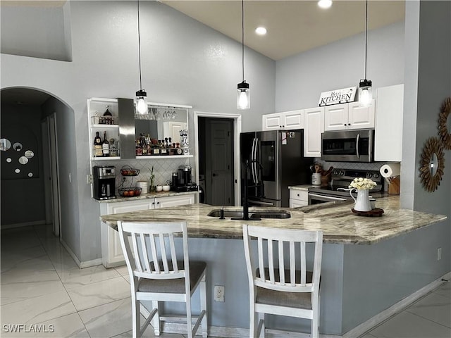 1839 Jovita Ave, Lehigh Acres, FL 33972 - kitchen with stainless steel appliances, light marble finish floors, a towering ceiling, decorative backsplash, and arched walkways