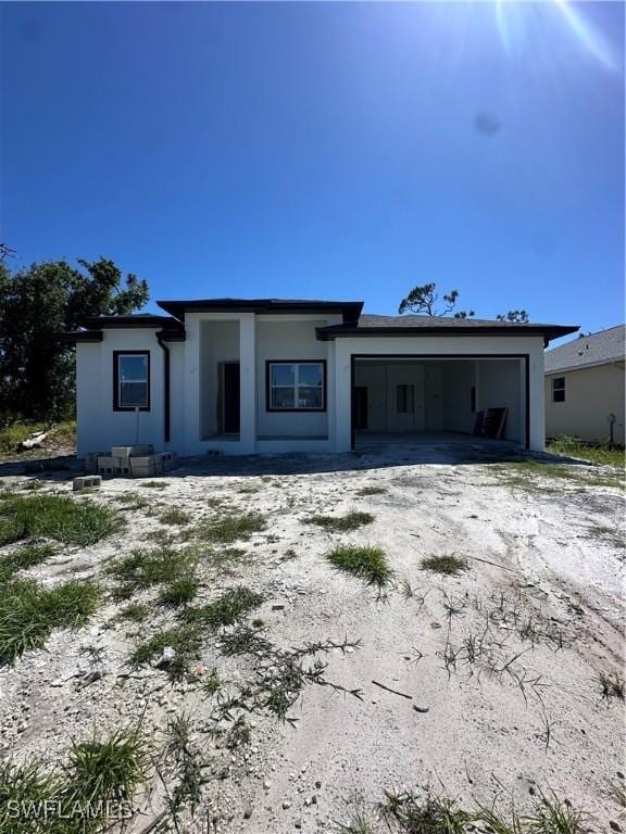 205 Australian Dr, Rotonda West, FL 33947 - view of front of property featuring driveway, an attached garage, and stucco siding