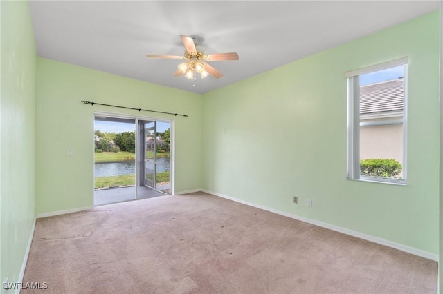 25941 Pebblecreek Dr, Bonita Springs, FL 34135 - spare room featuring carpet, a ceiling fan, baseboards, and a water view