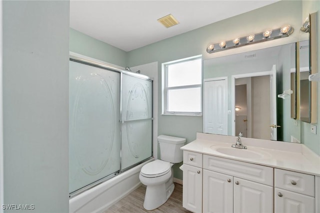 25941 Pebblecreek Dr, Bonita Springs, FL 34135 - bathroom featuring vanity, toilet, combined bath / shower with glass door, and wood finished floors