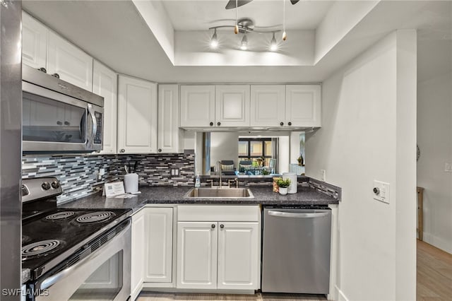 6142 Whiskey Creek Dr Unit 628, Fort Myers, FL 33919 - kitchen featuring stainless steel appliances, a sink, a raised ceiling, white cabinets, and decorative backsplash