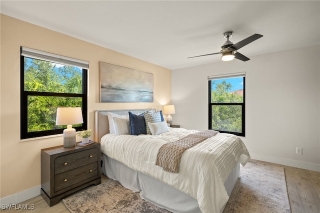 6142 Whiskey Creek Dr Unit 628, Fort Myers, FL 33919 - bedroom featuring multiple windows, light wood-style flooring, baseboards, and ceiling fan