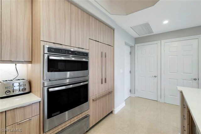 2728 Tiburon Blvd E Unit A403, Naples, FL 34109 - kitchen featuring double oven, light countertops, a warming drawer, light brown cabinetry, and recessed lighting