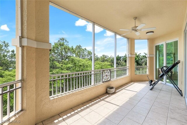 2728 Tiburon Blvd E Unit A403, Naples, FL 34109 - unfurnished sunroom with a textured wall, tile patterned floors, and view of scattered trees