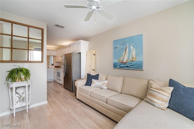 1160 Sarah Jean Cir Unit D204, Naples, FL 34110 - living room featuring light wood-style flooring, a ceiling fan, and baseboards