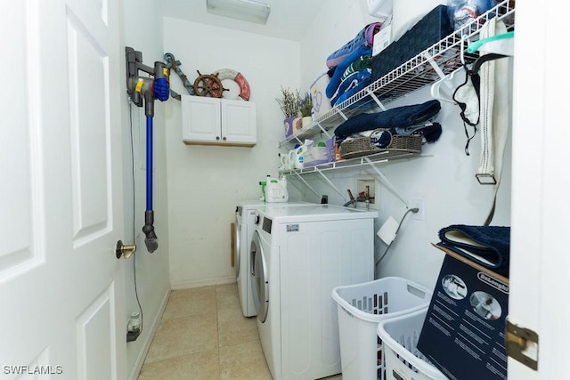 2140 8th St NE, Naples, FL 34120 - laundry area featuring washing machine and clothes dryer, cabinet space, light tile patterned floors, and baseboards