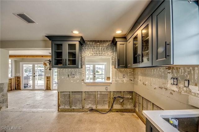 2685 Geary St, Matlacha, FL 33993 - kitchen with glass insert cabinets, healthy amount of natural light, recessed lighting, concrete floors, and french doors