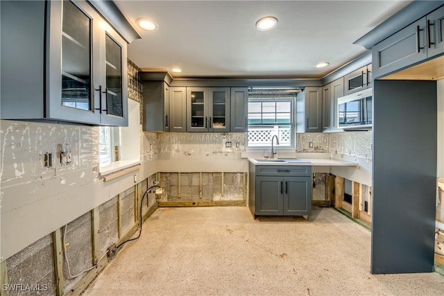 2685 Geary St, Matlacha, FL 33993 - kitchen with backsplash, glass insert cabinets, a sink, recessed lighting, and light countertops