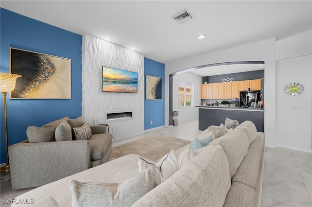 7384 Sika Deer Way, Fort Myers, FL 33966 - living room with recessed lighting, arched walkways, light marble finish flooring, baseboards, and a large fireplace