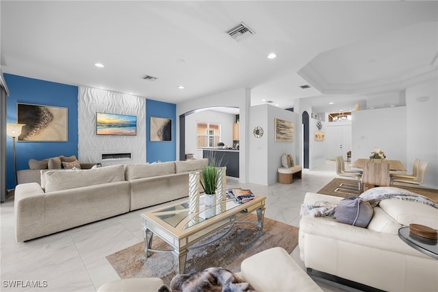 7384 Sika Deer Way, Fort Myers, FL 33966 - living room featuring arched walkways, light marble finish floors, recessed lighting, and a large fireplace
