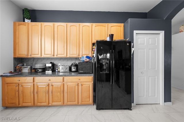 7384 Sika Deer Way, Fort Myers, FL 33966 - kitchen featuring black fridge with ice dispenser, dark countertops, light brown cabinets, baseboards, and decorative backsplash