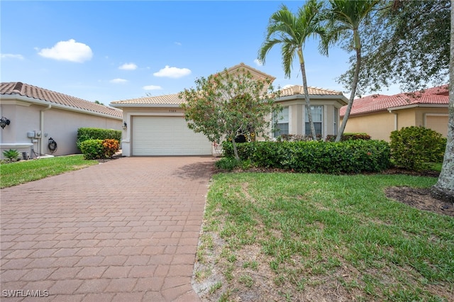 7384 Sika Deer Way, Fort Myers, FL 33966 - mediterranean / spanish home with decorative driveway, a garage, a tiled roof, stucco siding, and a front yard