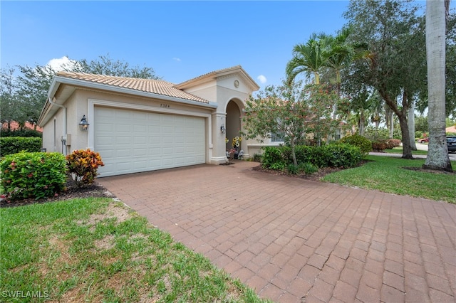 7384 Sika Deer Way, Fort Myers, FL 33966 - mediterranean / spanish-style home with a garage, decorative driveway, a tiled roof, and stucco siding
