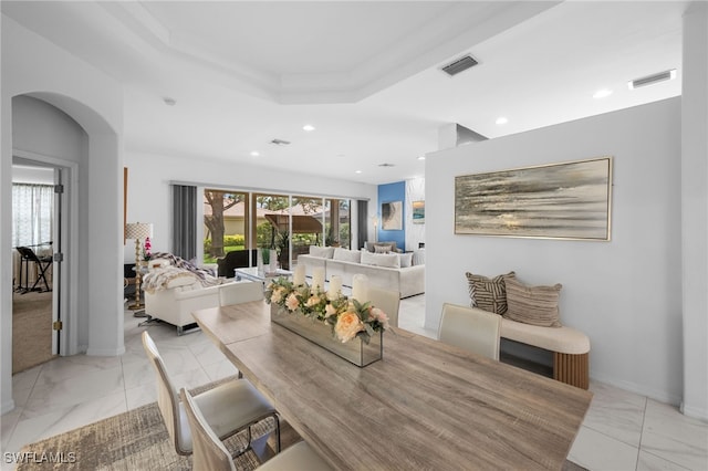 7384 Sika Deer Way, Fort Myers, FL 33966 - dining room featuring light marble finish floors, recessed lighting, arched walkways, a raised ceiling, and baseboards