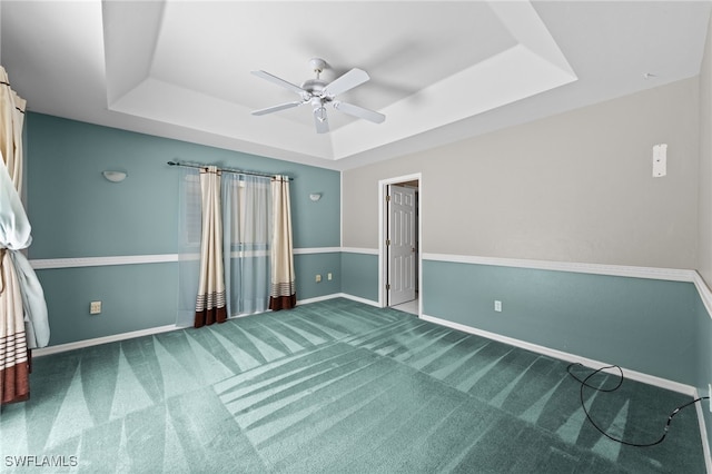 206 SE 12th Ter, Cape Coral, FL 33990 - unfurnished bedroom featuring a tray ceiling, carpet floors, baseboards, and a ceiling fan