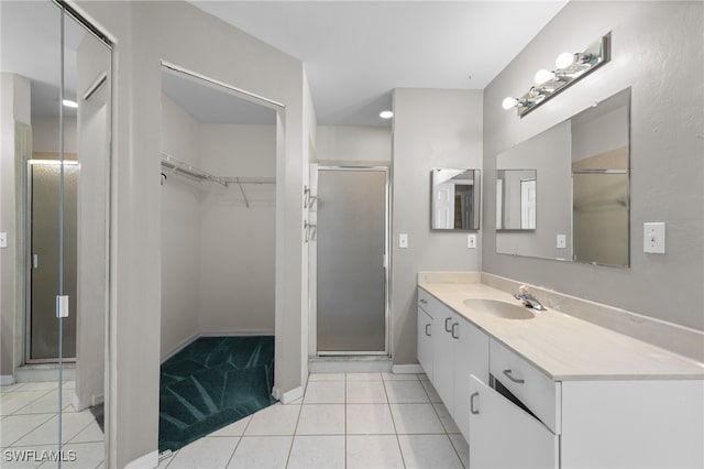 206 SE 12th Ter, Cape Coral, FL 33990 - full bathroom featuring vanity, a walk in closet, a stall shower, tile patterned floors, and baseboards