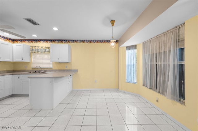 206 SE 12th Ter, Cape Coral, FL 33990 - kitchen with a peninsula, white cabinetry, a sink, light countertops, and recessed lighting